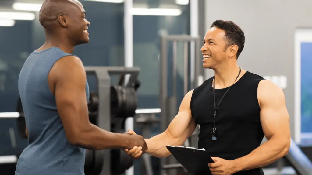 Personal trainer shaking hands with client