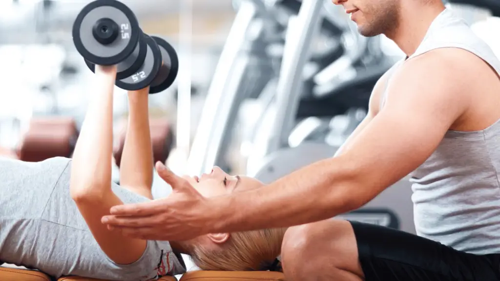 Woman exercising with, being guided by her trainer