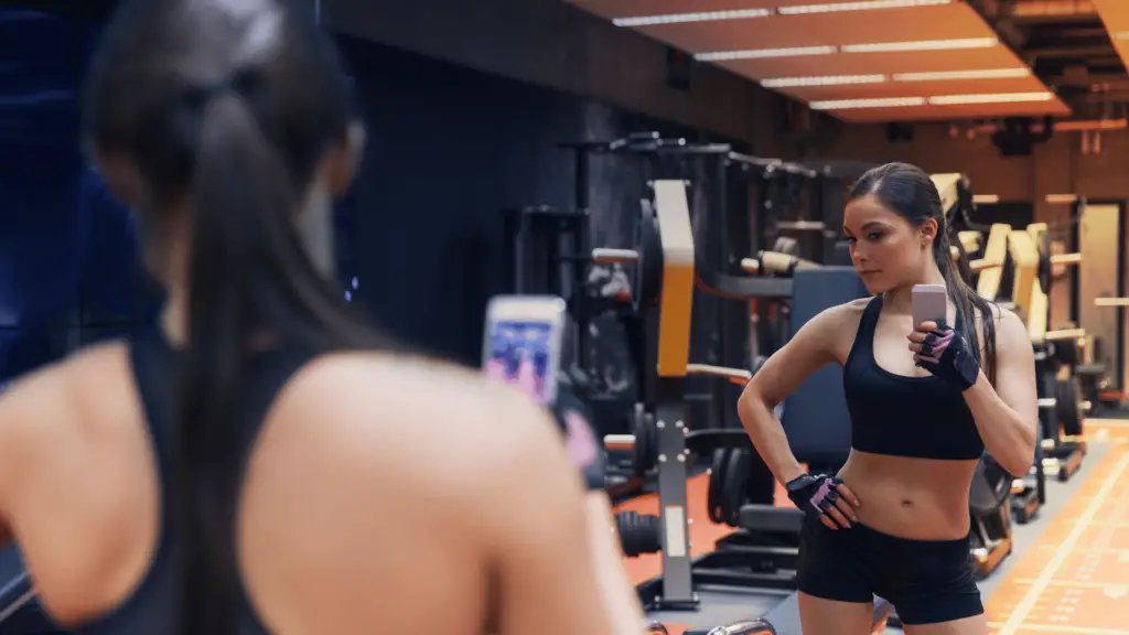 Woman taking mirror selfie at a gym