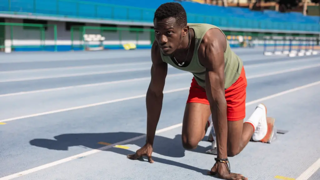 Black runner starting a race