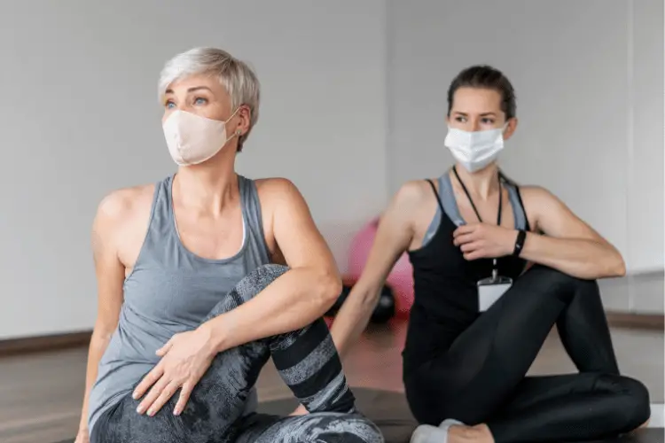 Woman stretching with her personal trainer