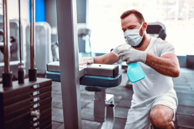 Man cleaning gym equipment 