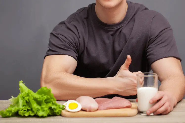 bodybuilder posing with protein rich foods 