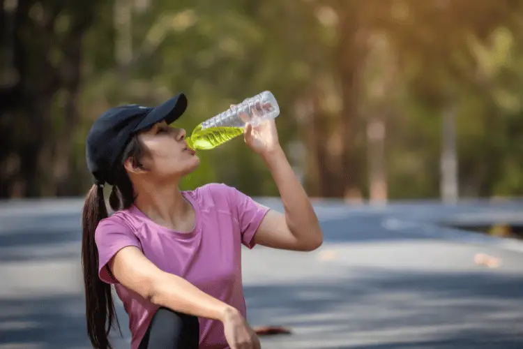 Athletic woman drinking an electrolyte drink