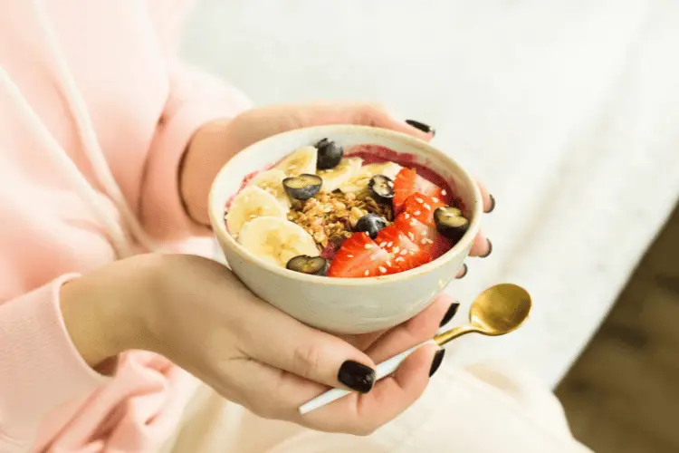 A woman holing a bowl of healthy food