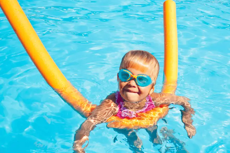 Little girl wearing swimming goggles in a pool