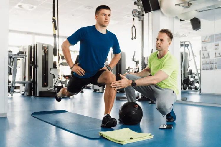 Young athlete doing exercises with his personal trainer